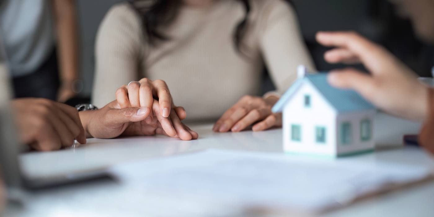 Couple signing a home contract, illustrating a Colorado beneficiary deed