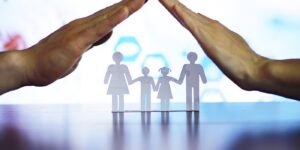 Hands protecting a paper family, symbolizing estate planning protection