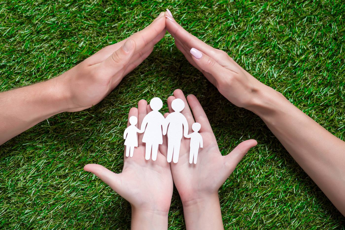 Hands holding a paper cutout of a family, symbolizing inheritance protection