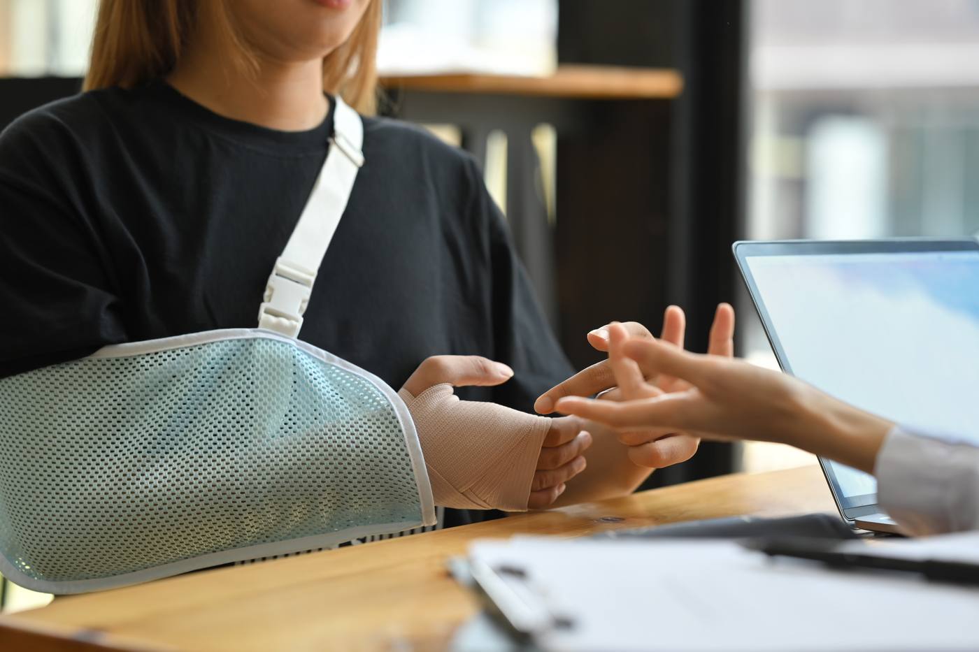 Injured woman with arm sling consulting about her personal injury claim