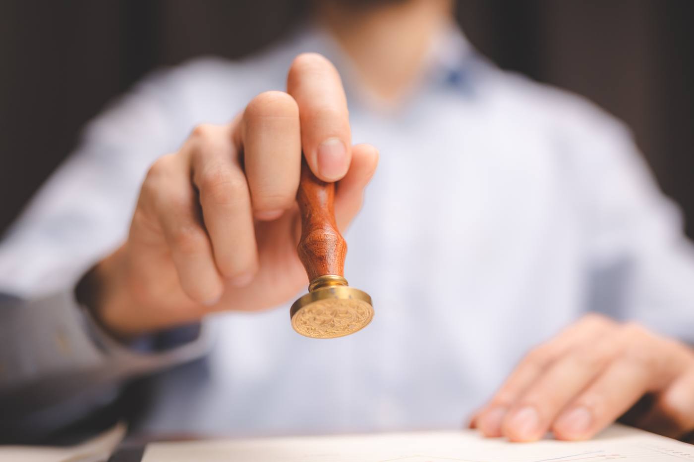 Professional applying an embossed notary stamp to official documents