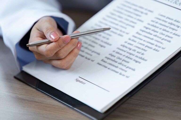 Hand with pen signing a Colorado power of attorney document