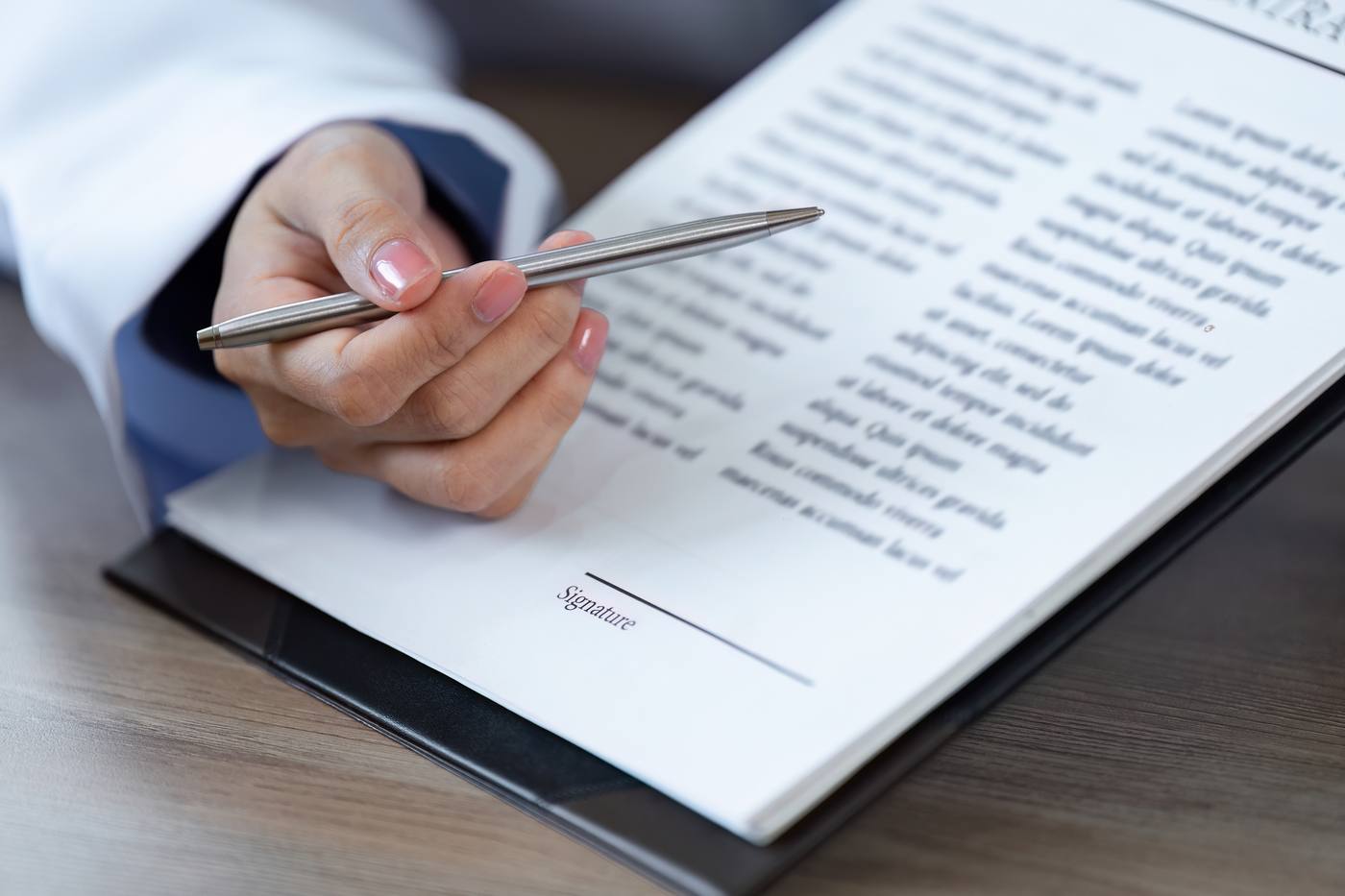Hand with pen signing a Colorado power of attorney document