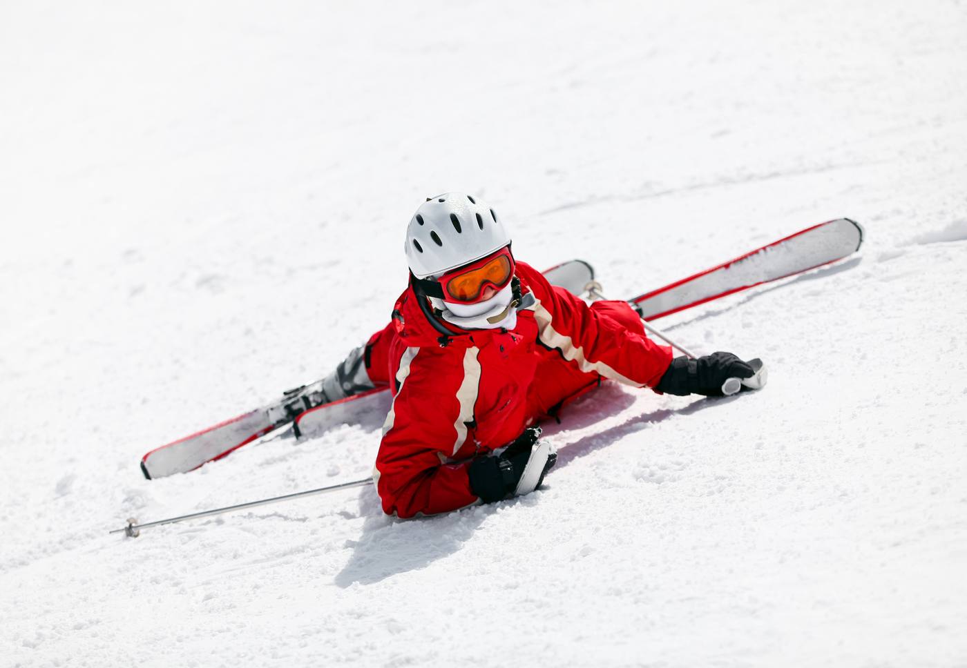Adult skier lying in the snow after a fall